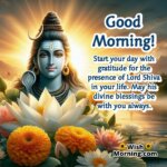 A divine morning image of Lord Shiva with open eyes, looking directly at the viewer, surrounded by marigold and lotus flowers, with a golden sunrise and a calm river in the background. The text wishes a good morning with gratitude for Lord Shiva’s blessings.